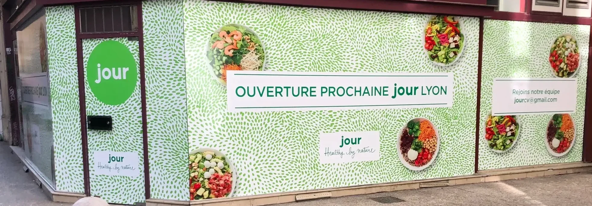 Photo vitrine de magasin habillée avec une vitrophanie publicitaire attirant l’attention des passants